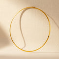 Collana girocollo rigido dorato.