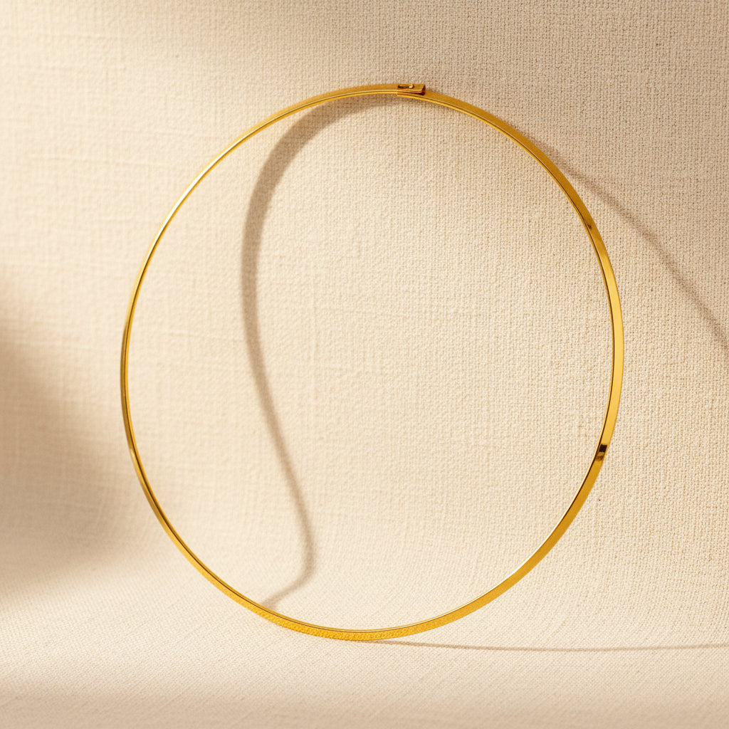 Collana girocollo rigido dorato.
