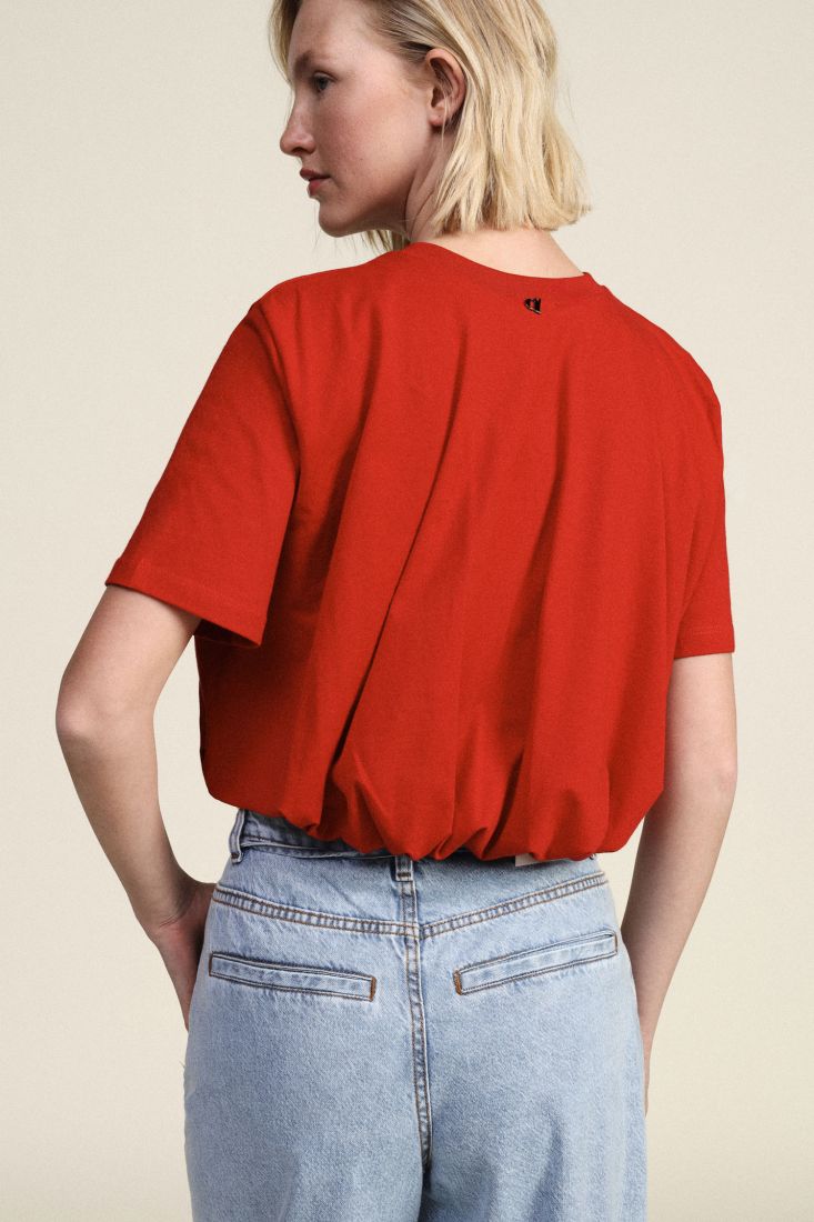T-shirt cropped con arricciatura sul fondo rosso