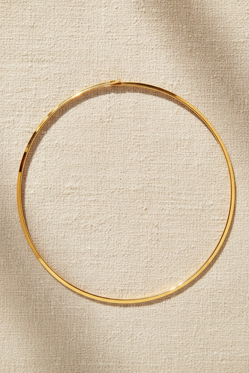 Collana girocollo rigido dorato.