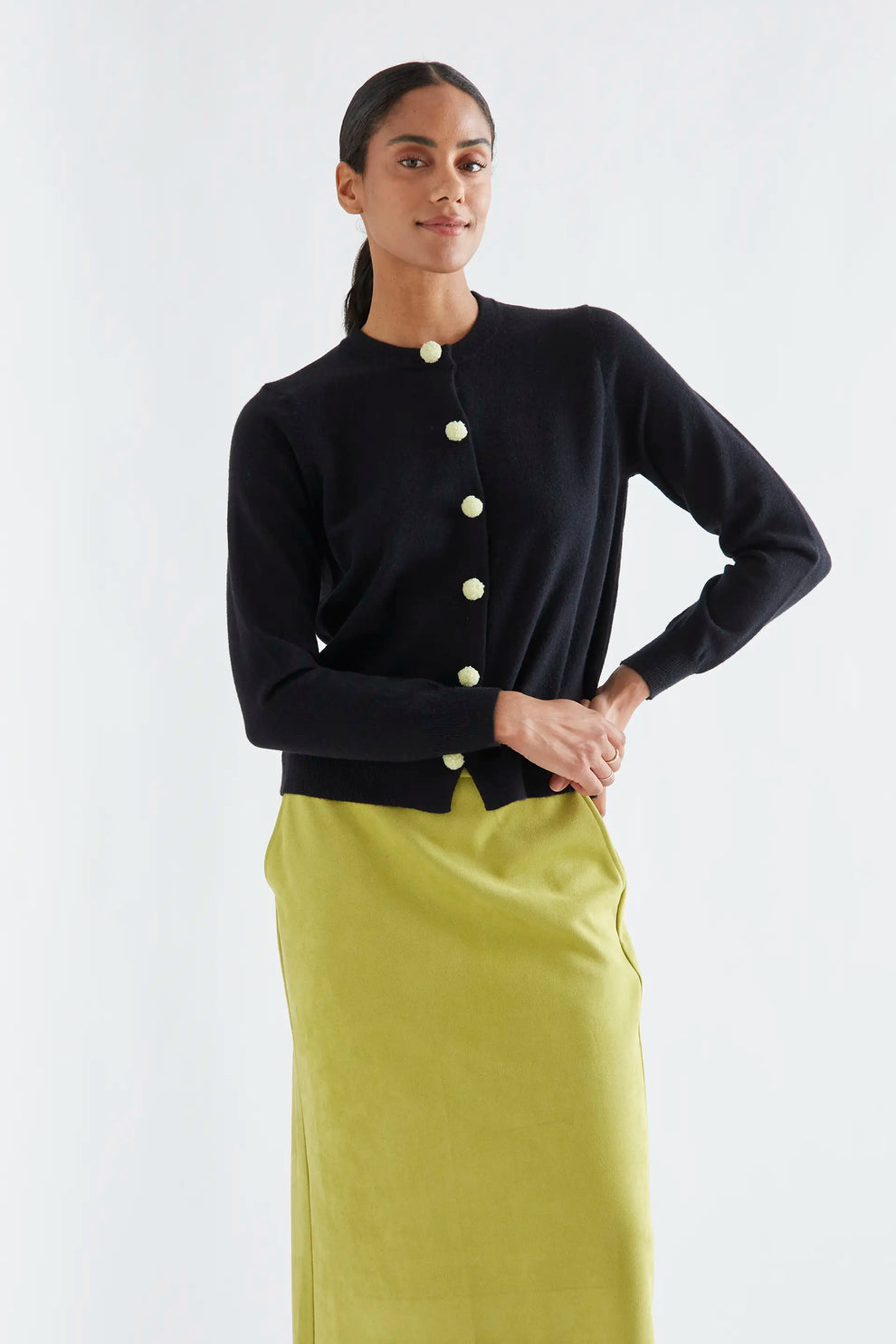 Cardigan nero con pon pon gialli